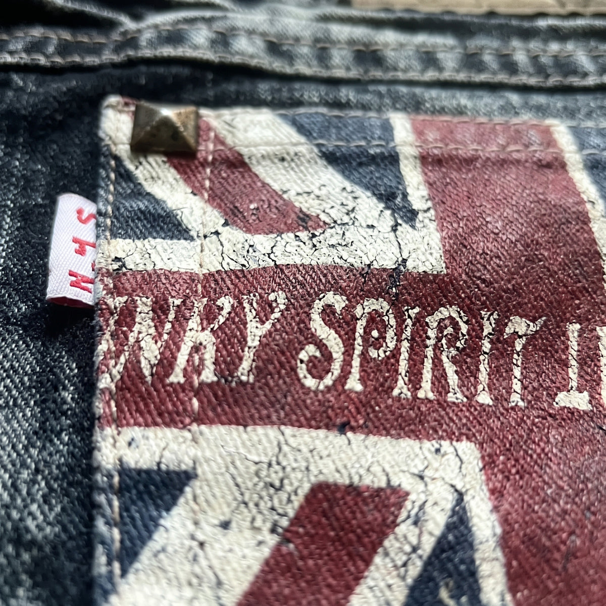 Macro detail of the Union Jack back pocket on the British Flag denim shorts