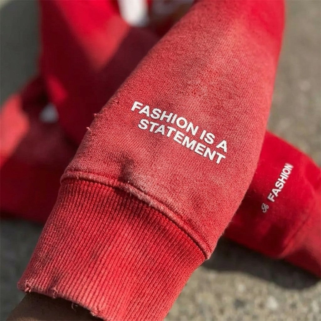 Sleeve detail of the red I Am Art hoodie reading Fashion Is A Statement