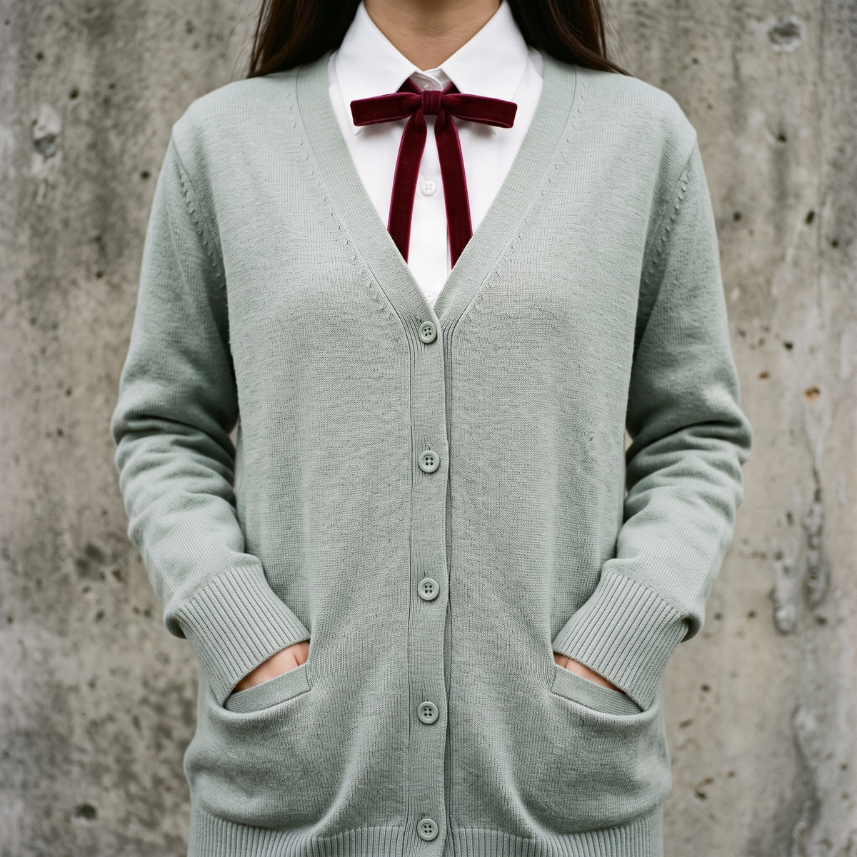 Close-up of the sage cardigan V neckline, button placket and burgundy ribbon tie