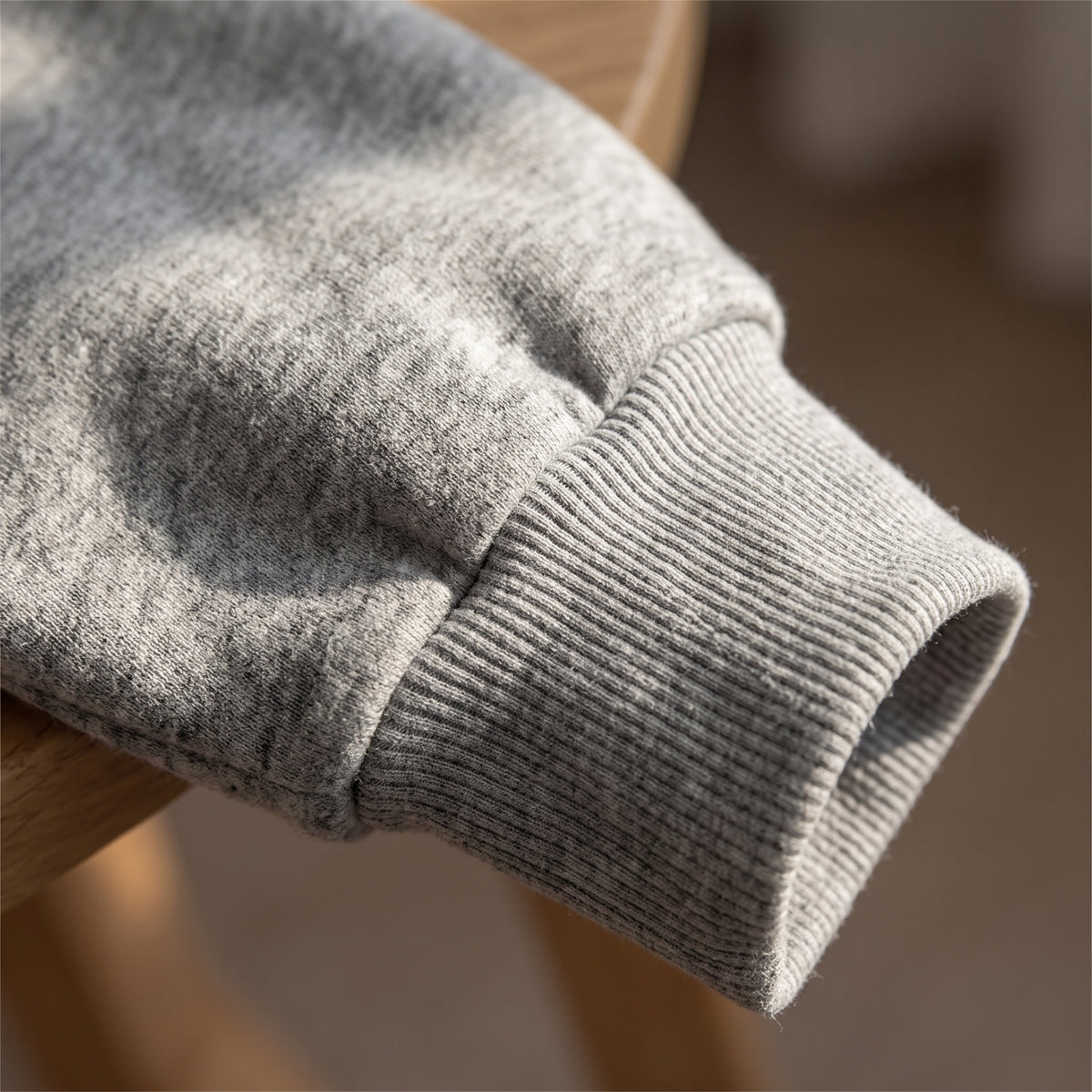 Detail of the heather grey marl fleece and ribbed cuff of the Mershier sweatshirt